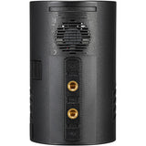 The rear view of a black cylindrical speaker, showing a textured grille, a vented section, and two gold-toned audio input jacks on a plain white background.