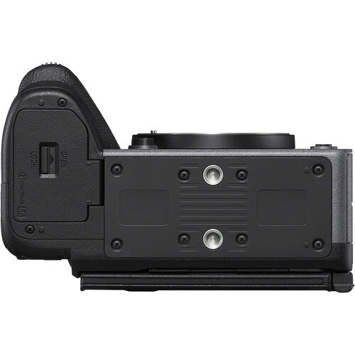 The top-down view of a black mirrorless camera body with an attached vertical grip, showing the textured grip, control buttons, and mounting plate against a white background.