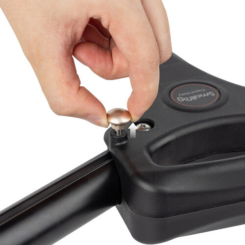 Hand using a tool to adjust a screw on a black device with 'Brüllows' branding.