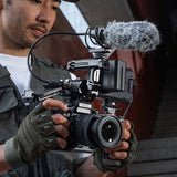Person holding a professional camera with microphone attachment