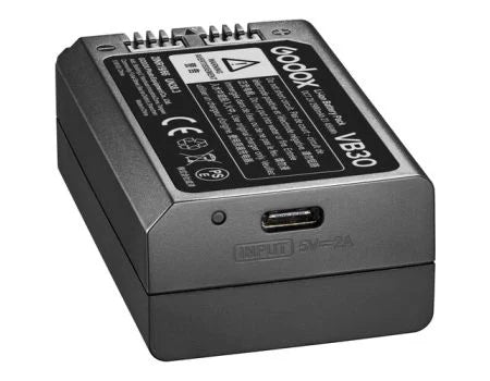 A Godox VB30 rechargeable camera battery shown from a three-quarters angle, featuring a matte dark gray body, a USB-C port, and a detailed specification label on top.