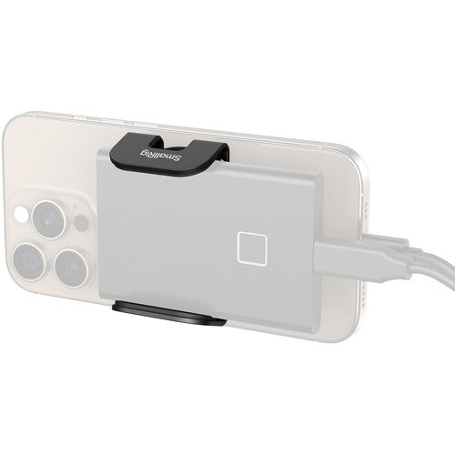 A silver rectangular electronic accessory with a black clip mounted on the back of a smartphone, with a white cable plugged into it, shown on a plain white background.